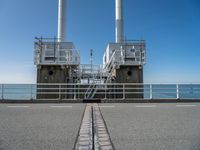 the sea side of a pier with a metal staircase going to it next to the water