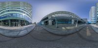 three circular mirrors showing people walking in front of buildings and a building with a glass wall in the middle of it