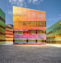 a large multi - colored building has many windows and colors painted on it's sides