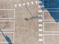 an overhead shot shows the pavement and parking spaces of a large commercial lot on the right side