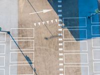 an overhead shot shows the pavement and parking spaces of a large commercial lot on the right side