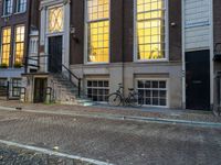 the reflection of a building on the street has been captured by the street light of the bike in the window