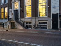 the reflection of a building on the street has been captured by the street light of the bike in the window