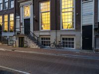 the reflection of a building on the street has been captured by the street light of the bike in the window