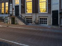 the reflection of a building on the street has been captured by the street light of the bike in the window