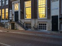 the reflection of a building on the street has been captured by the street light of the bike in the window