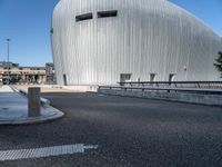 a building has an unusual design, with windows, a dome and a small fountain in the street