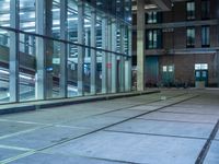 empty street with glass and metal buildings in the background and on the other side a bike parking lot