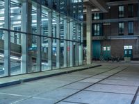 empty street with glass and metal buildings in the background and on the other side a bike parking lot