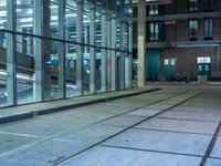 empty street with glass and metal buildings in the background and on the other side a bike parking lot