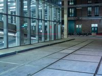 empty street with glass and metal buildings in the background and on the other side a bike parking lot