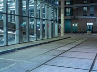 empty street with glass and metal buildings in the background and on the other side a bike parking lot