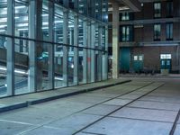 empty street with glass and metal buildings in the background and on the other side a bike parking lot