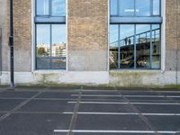 a building with two parking spaces behind it in an empty lot next to a street