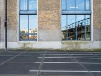 a building with two parking spaces behind it in an empty lot next to a street