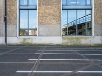 a building with two parking spaces behind it in an empty lot next to a street