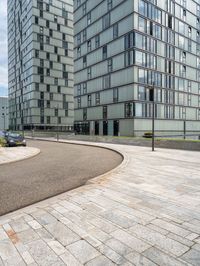 an empty paved parking space is next to some buildings with windows and a black car