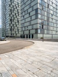 an empty paved parking space is next to some buildings with windows and a black car