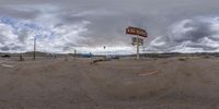 the desert is very barren and dirt on the ground in front of the street sign