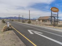 a deserted highway with a street sign that reads high school with an arrow pointing to the road