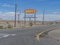 the sign of route 66 in the deserted town of texas, with road and vacant business