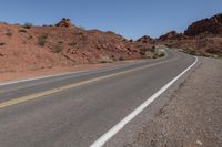 a person riding on a motorcycle down a winding road in the mountains of arizona, usa