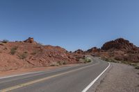 a person riding on a motorcycle down a winding road in the mountains of arizona, usa