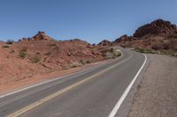 a person riding on a motorcycle down a winding road in the mountains of arizona, usa