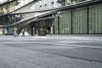a building with a curved metal facade and windows on it's side by the street
