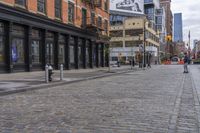 the bricked streets with tall buildings have posters on them as a place to be photographed