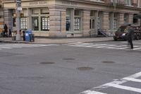 the person is crossing the street at this crosswalk intersection to get there car to be seen