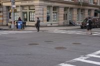 the person is crossing the street at this crosswalk intersection to get there car to be seen