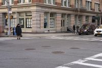 the person is crossing the street at this crosswalk intersection to get there car to be seen