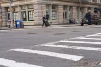 the person is crossing the street at this crosswalk intersection to get there car to be seen