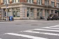 the person is crossing the street at this crosswalk intersection to get there car to be seen