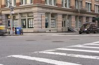 the person is crossing the street at this crosswalk intersection to get there car to be seen