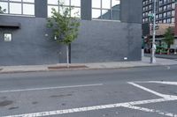 a paved road with a stop light at an intersection near a building with an arrow painted on it