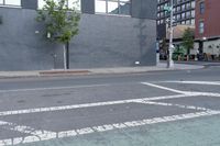 a paved road with a stop light at an intersection near a building with an arrow painted on it