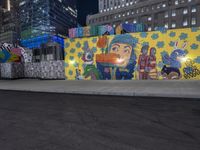 street with large graffiti wall along the side of it near a city street with buildings