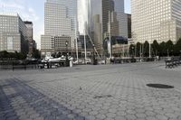 a harbor with many different boats on it with skyscrapers in the background and people sitting on benches looking out at the water