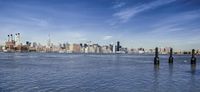the lower manhattan buildings are on the horizon of a city lake with boats passing by