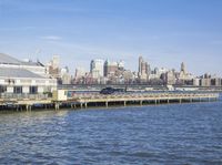 a dock and the city skyline with buildings in the background that is almost empty with water and large buildings on both sides