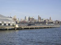 a dock and the city skyline with buildings in the background that is almost empty with water and large buildings on both sides