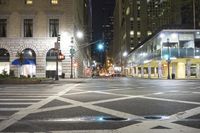 a city street that has cars parked on the side of it at night and a light post in the center