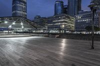 a view of new york city skyline at night from pier on the hudson river side