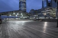 a view of new york city skyline at night from pier on the hudson river side