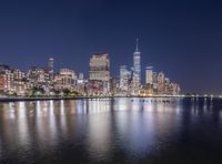 a night time photograph of the skyline of new york city with manhattan in the background