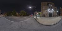 an image of a street that is in the night time on a panoramic lens