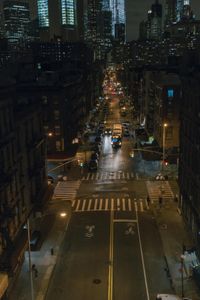 an aerial view of a city intersection at night, with lots of cars moving through the streets