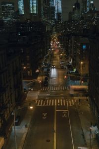 an aerial view of a city intersection at night, with lots of cars moving through the streets